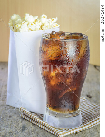 Cola with ice and popcorn on a wooden. Cola with ice and popcorn on a wooden. 26271434