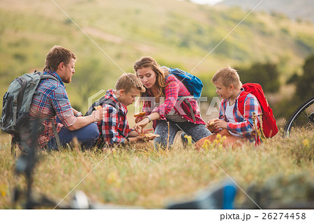 Family of four people eating fastfood in mountains Family of four people eating fastfood in mountains 26274458