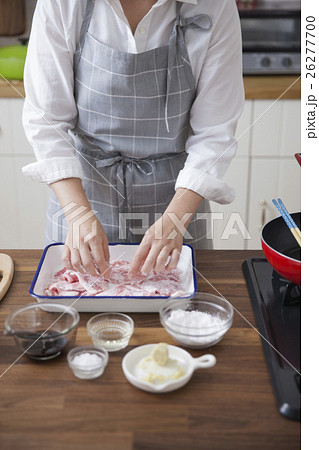 豚薄切り肉に小麦粉をまぶす女性 豚薄切り肉に小麦粉をまぶす女性 26277700