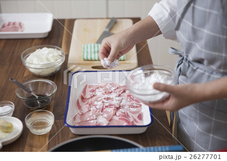 豚薄切り肉に小麦粉をまぶす女性 26277701
