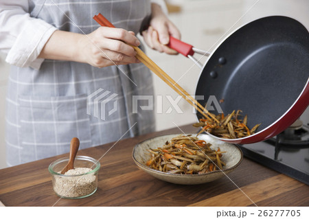 きんぴらごぼうを菜箸で器に盛り付ける女性 26277705