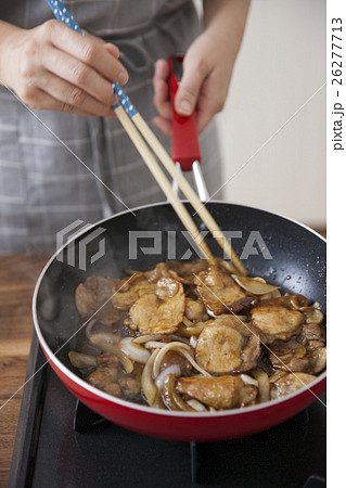 焼いた豚薄切り肉に味付けをする女性 26277713