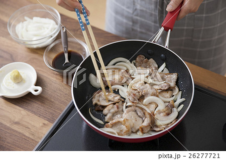 豚薄切り肉と玉ねぎをフライパンで焼く女性 26277721