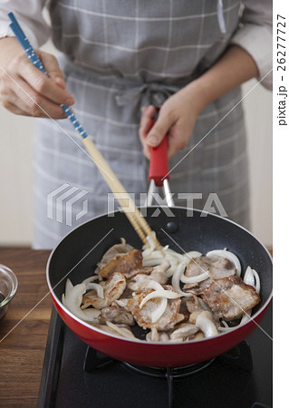 豚薄切り肉と玉ねぎをフライパンで焼く女性 26277727