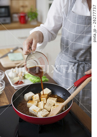 挽肉と豆腐に合わせ調味料をかける女性 26277737