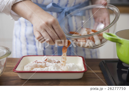 エビに小麦粉をまぶす女性の写真素材