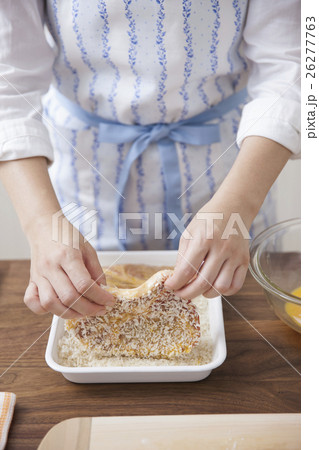 豚ロース肉にパン粉をつける女性 26277763