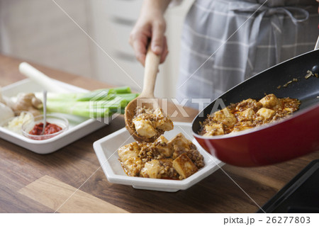 麻婆豆腐を器に盛り付ける女性 26277803