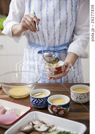 卵液を茶碗蒸しの容器に注ぎ入れる女性 卵液を茶碗蒸しの容器に注ぎ入れる女性 26277836