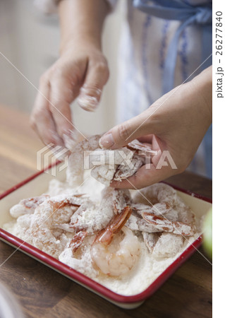 エビに小麦粉をまぶす女性の写真素材