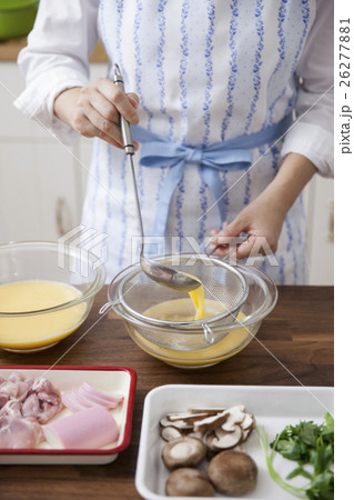だしが入った卵液を濾す女性 26277881