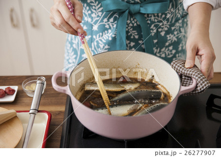 梅干しと煮汁でイワシを煮る女性 26277907