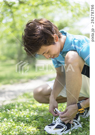 靴ひもを結ぶ男性の写真素材