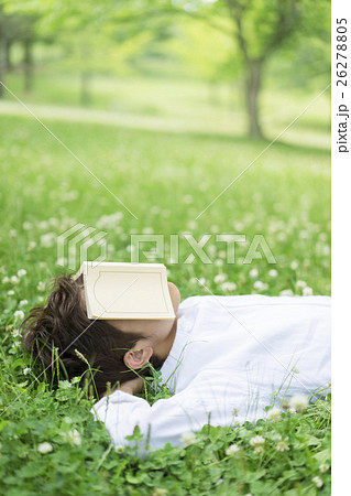 本で顔を覆う日本人男性の写真素材