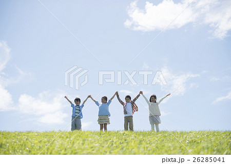 草原で手をつなぐ小学生の写真素材