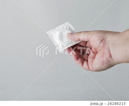 Hand holding a condom on white background Hand holding a condom on white background 26286215