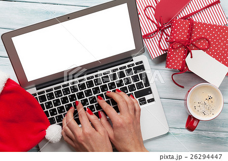 Female working on laptop and wrapping gifts 26294447