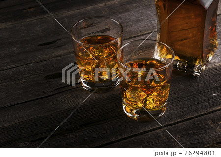 Whisky in two glasses on a dark wooden background Whisky in two glasses on a dark wooden background 26294801