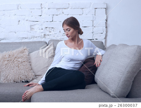 Beautiful girl sitting on a sofa in blue tones 26300037