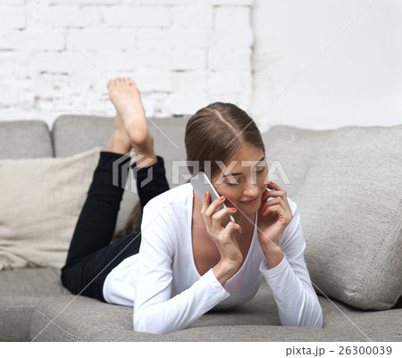 Beautiful girl lying on couch and talking on phone 26300039