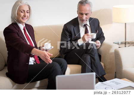 Happy businesswoman drinking coffee with her 26312077