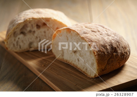 halves of fresh ciabatta on olive cutting board 26328907
