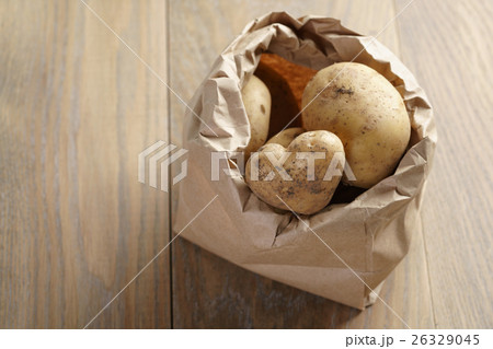 fresh potatoes in kraft paper bag on oak table 26329045