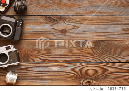 Vintage cameras and lenses on wooden background 26334756