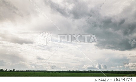 beautiful clouds over green field and forest 26344774
