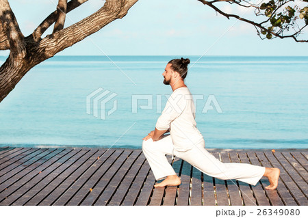 Man in white clothes meditating yoga on wooden Man in white clothes meditating yoga on wooden 26349080