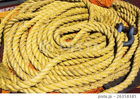 Coil of yellow rope with hook Coil of yellow rope with hook 26358385