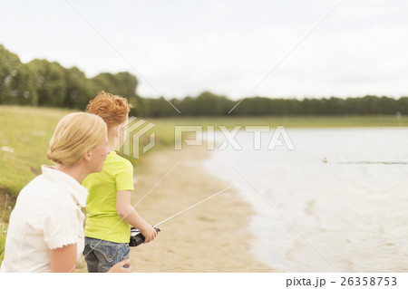 Mother and son (8-9) playing with radio controlled motorboat on lake Mother and son (8-9) playing with radio controlled motorboat on lake 26358753