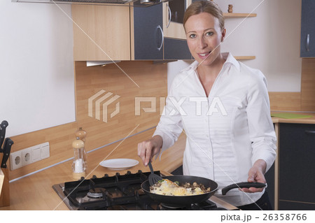 Woman preparing scrambled eggs 26358766