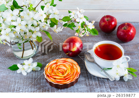 Apple shaped roses pie and cup of tea wooden table 26359877
