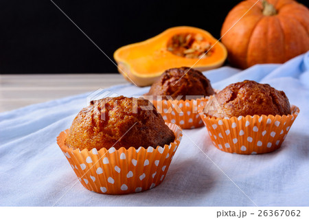 Pumpkin muffins in orange wrappers on blue napkin Pumpkin muffins in orange wrappers on blue napkin 26367062