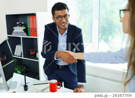 Modern business man with arm extended to handshake Modern business man with arm extended to handshake 26367709