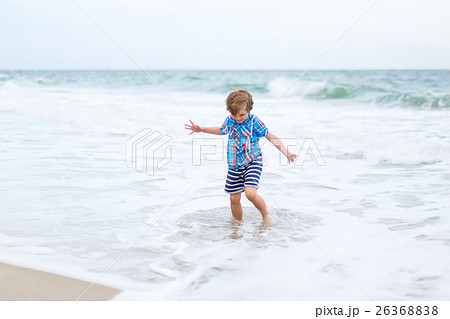 little kid boy running on the beach of ocean little kid boy running on the beach of ocean 26368838