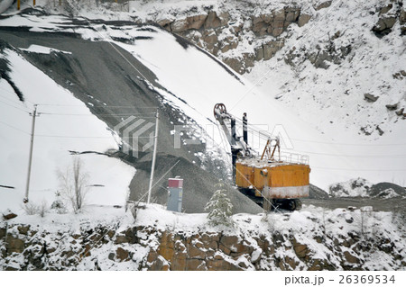 big huge yellow excavator in granite quarry winter big huge yellow excavator in granite quarry winter 26369534
