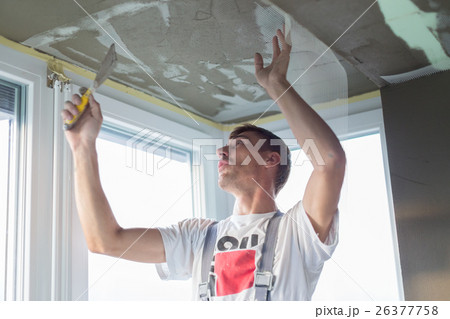 Plasterer renovating indoor walls and ceilings 26377758