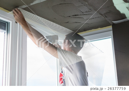 Plasterer renovating indoor walls and ceilings 26377759