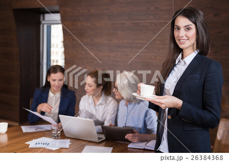 Pretty woman posing in office with colleagues Pretty woman posing in office with colleagues 26384368