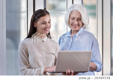 Young woman and her elderly boss working on laptop Young woman and her elderly boss working on laptop 26384538