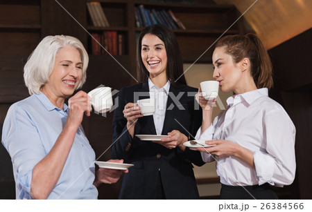 Amused colleagues drinking coffee in an office Amused colleagues drinking coffee in an office 26384566