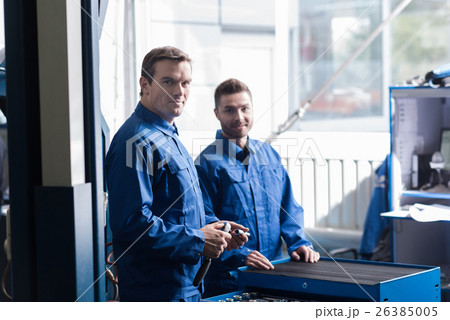 Positive mechanics standing in car service center 26385005
