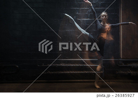 Young gymnast in motion in the dark lighted room 26385927