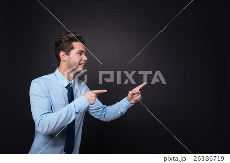 Cheerful businessman pointing aside. 26386719