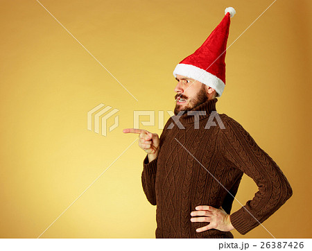 The serious christmas man wearing a santa hat The serious christmas man wearing a santa hat 26387426