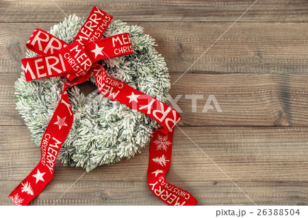 Christmas wreath, red ribbon on wooden background Christmas wreath, red ribbon on wooden background 26388504