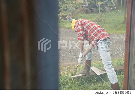 田舎暮らし　のこぎりで作業する男性 26389905