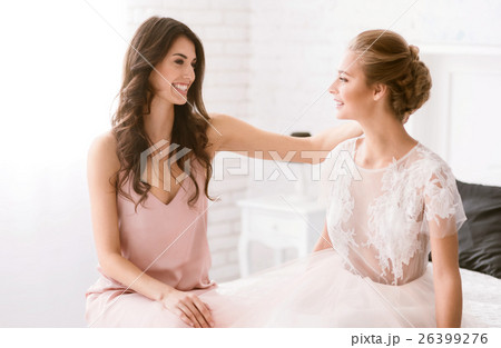 Delighted bridesmaid congratulates the bride with 26399276